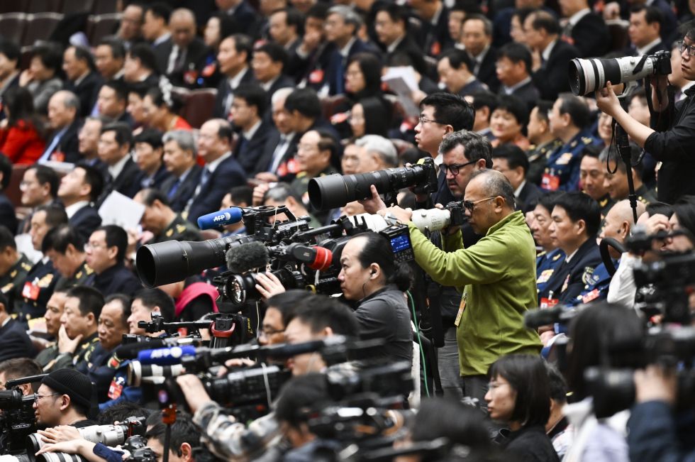 3月8日，记者在十四届全国人大二次会议第二次全体会议上采访拍摄。新华社记者 牟宇 摄