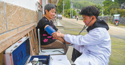 江西省宜春市奉新县石溪管委会桐木村村医胡依文在给村民量血压。  周 亮摄（影像中国）