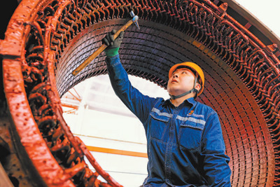 在包（头）神（木）铁路机务分公司东胜检修设备车间，青年职工正对机车主发电机部件进行质量检查。  张 枨 李尚昆摄影报道