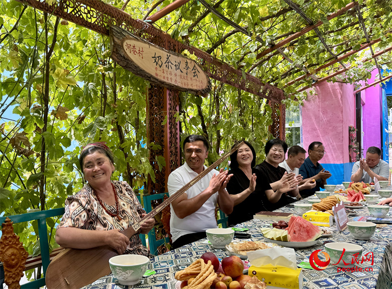 在惠远镇河巷村举行的“奶茶会”上,村民弹起都塔尔,唱出幸福生活。人民网 李龙摄 在惠远镇河巷村举行的“奶茶会”上,村民弹起都塔尔,唱出幸福生活。人民网 李龙摄