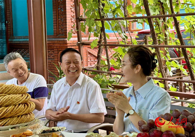 伊犁州政协委员、州工商联副主席华佳奎（中）参加&ldquo;奶茶议事会&rdquo;。人民网 李龙摄