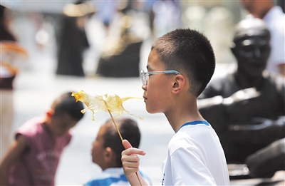 8月4日，前门大街，小朋友品尝糖人。新京报记者 李木易 摄