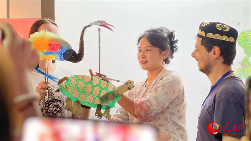 在昌吉美术馆,中外汉学家、翻译家、作家参观非遗展厅,观看、体验非遗项目。人民网 李欣洋摄 在昌吉美术馆,中外汉学家、翻译家、作家参观非遗展厅,观看、体验非遗项目。人民网 李欣洋摄
