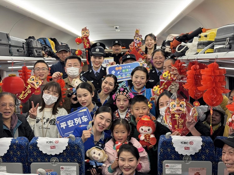 春节期间，在中老铁路磨万（磨丁&mdash;万象）段，铁路客运员工与乘客合影留念。李加勇摄