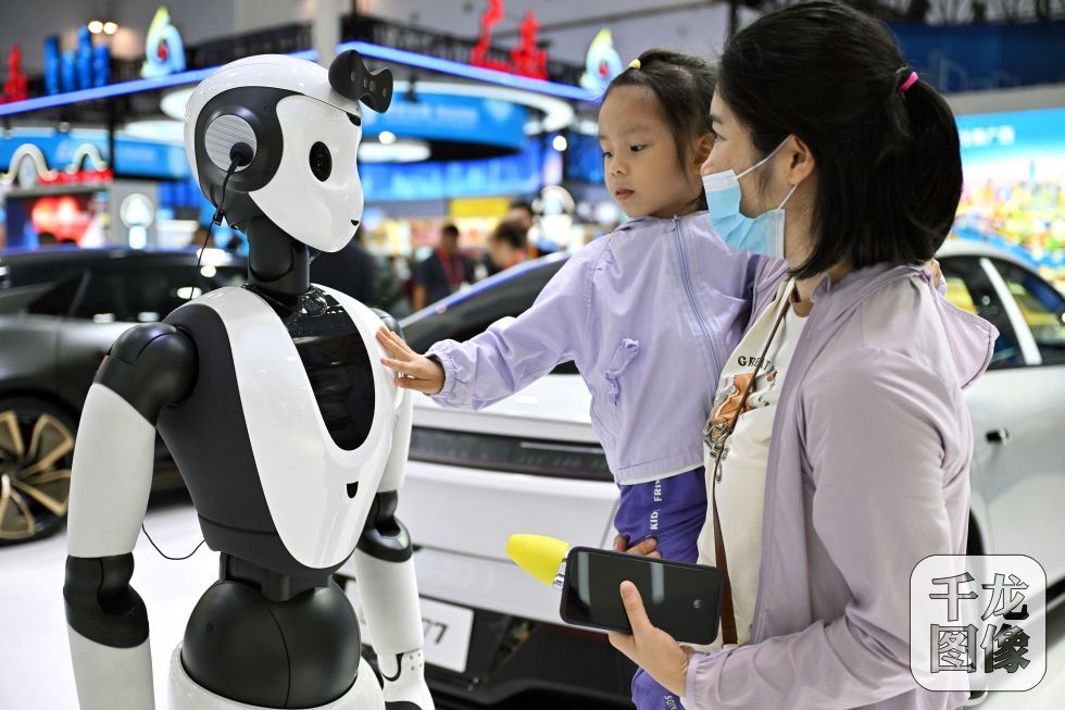 2024年 4月15日，观众在消博会上与AI人形智能服务机器人互动。新华社记者 郭程 摄