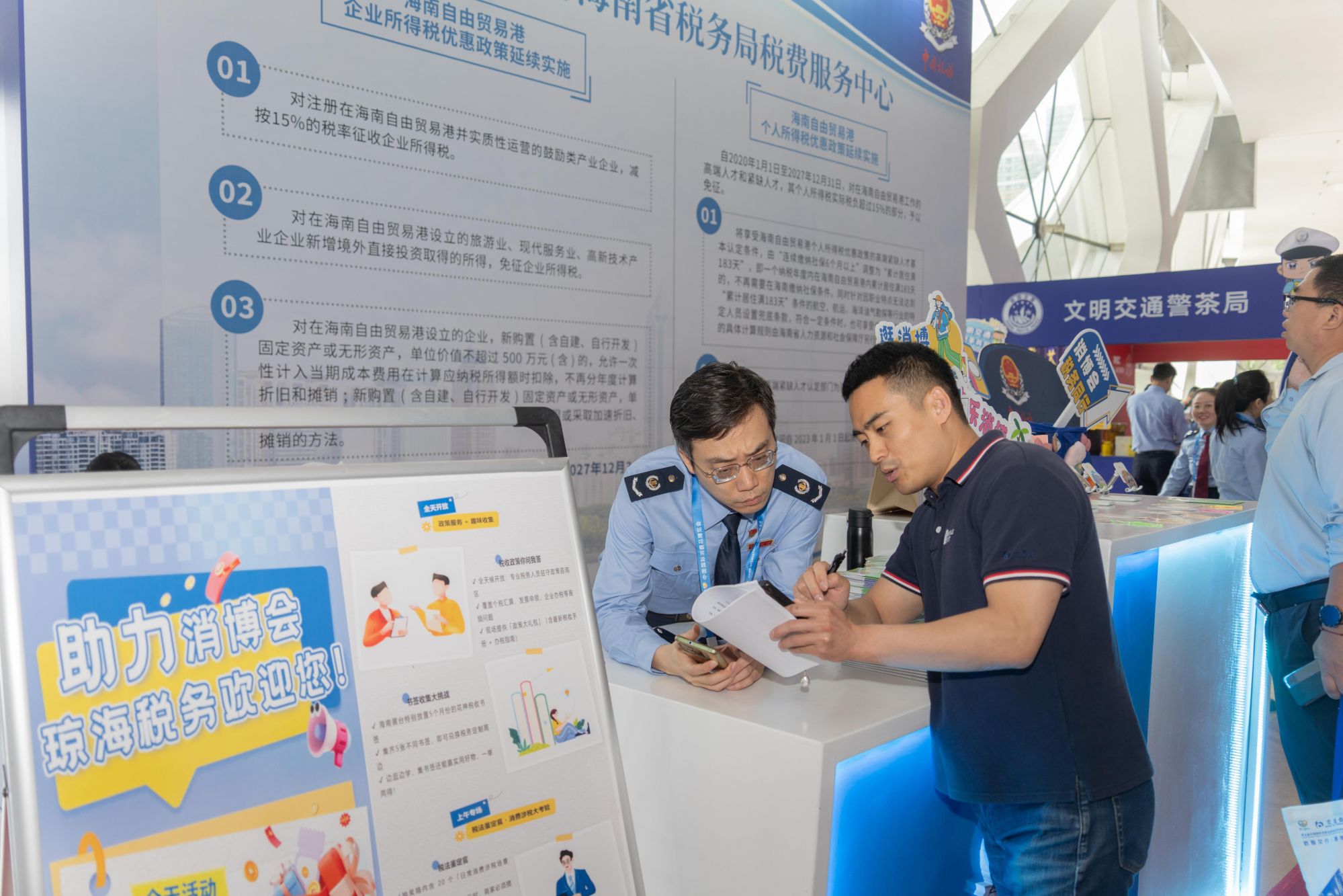 税务服务台工作人员向记者介绍服务参展外商的具体举措。人民网记者 许峥摄