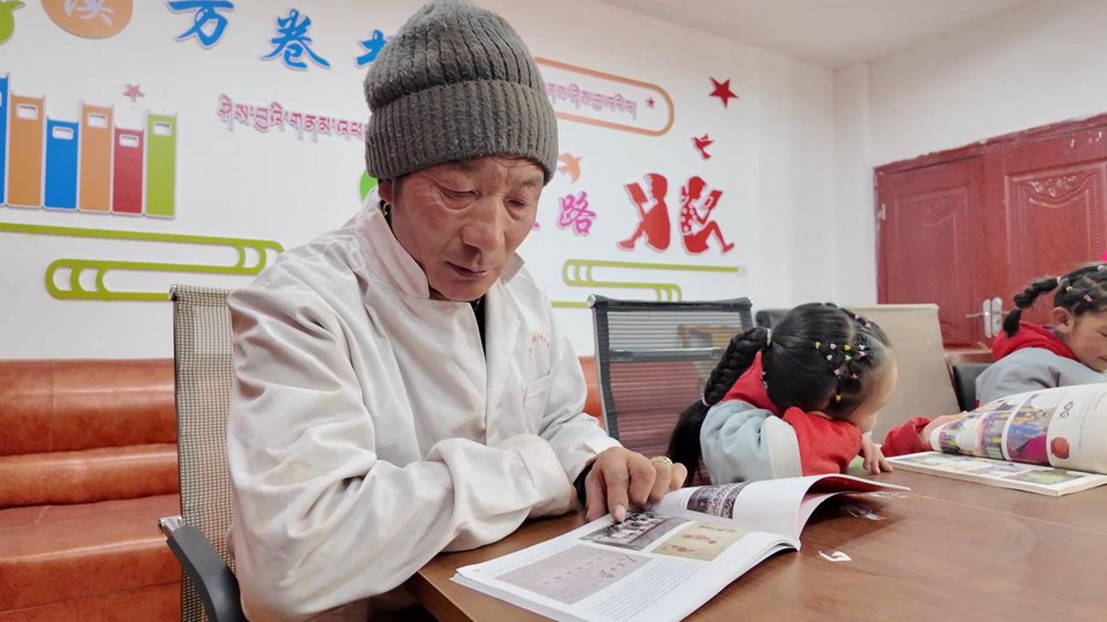 一位当地村民和孩子们在牧家书屋里尽情享受阅读时光。申扎县融媒体中心供图