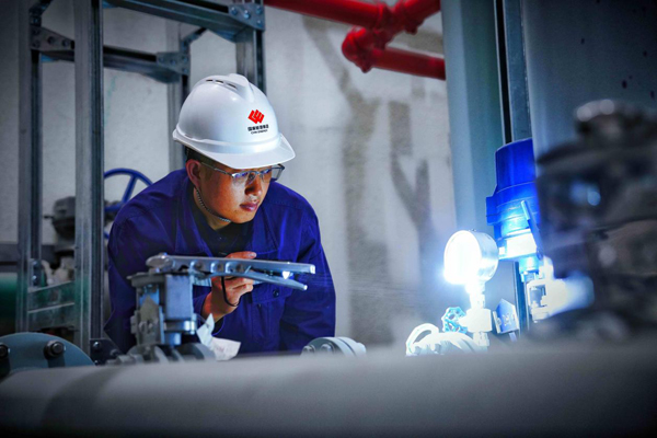 王宇在3号发电机组下机架观察油冷却器情况。张海轩摄