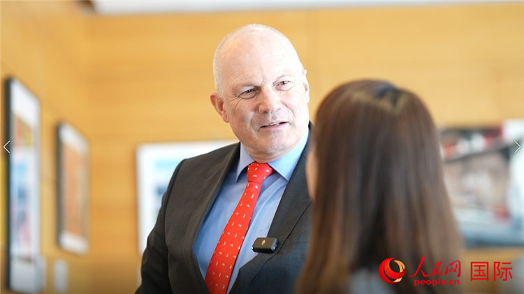 瑞士驻华大使白瑞谊介绍使馆内陈列的照片。人民网 彭昱凯摄