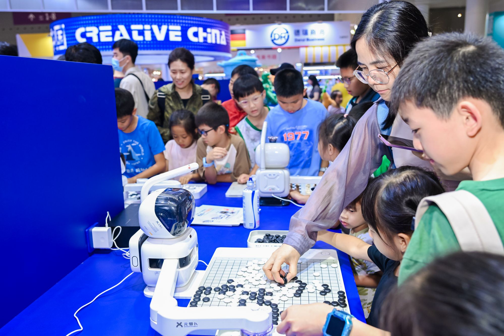 机器人和现场观众下棋。主办方供图