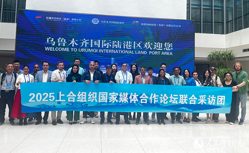 5月26日,外国媒体人在乌鲁木齐国际陆港区合影留念。 人民网记者 翟转丽摄