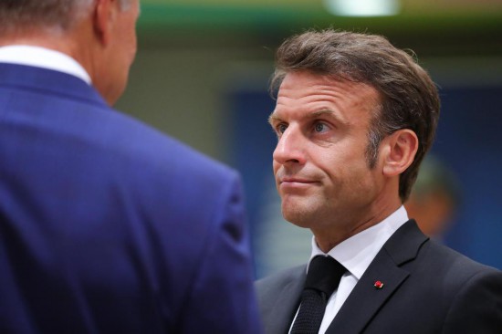 2023年6月29日,在比利时布鲁塞尔,法国总统马克龙(右)准备出席欧盟峰会。新华社记者郑焕松摄