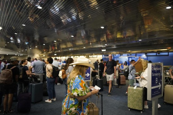2024年7月19日,乘客在美国密尔沃基国际机场排队办理手续。新华社记者吴晓凌摄
