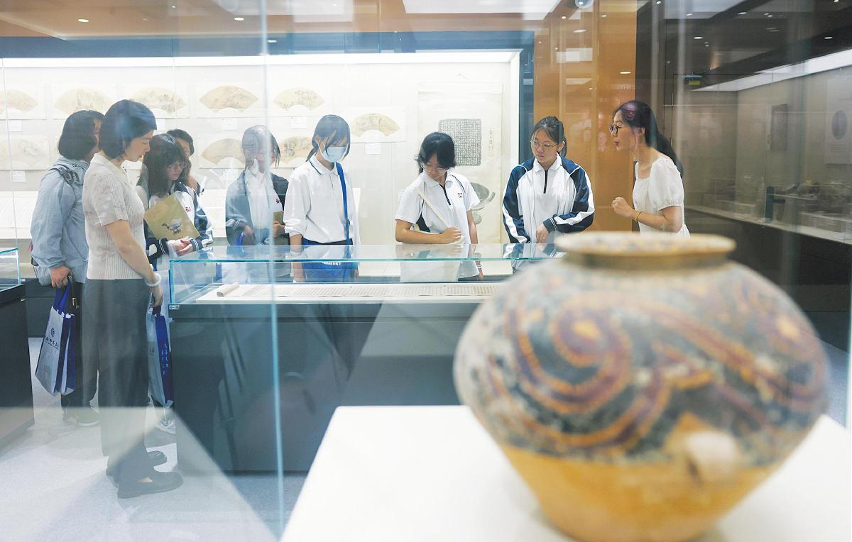 7月10日，首都师范大学历史博物馆，讲解老师为学生讲解馆藏文物。今年暑假，北京大学、北京交通大学、北京航空航天大学、北京师范大学等22所首都高校的43个博物馆面向中小学生和社会公众开放。观众可以通过电话、官网、微信公众号等途径预约参观，也可以通过“北京教育新地图”小程序平台预约。 新京报记者 李木易 摄