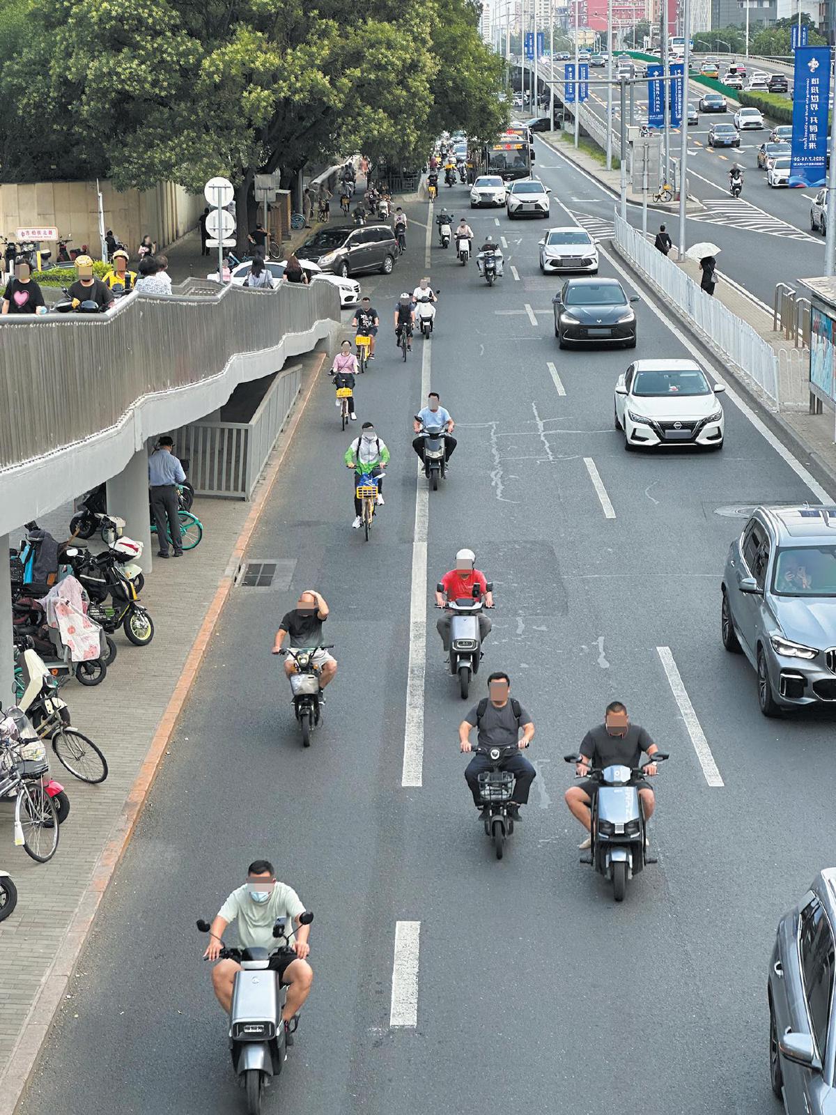 7月14日,东三环中路辅路南向北方向,不少电动自行车骑行者未佩戴头盔。 摄影/新京报记者 王贵彬