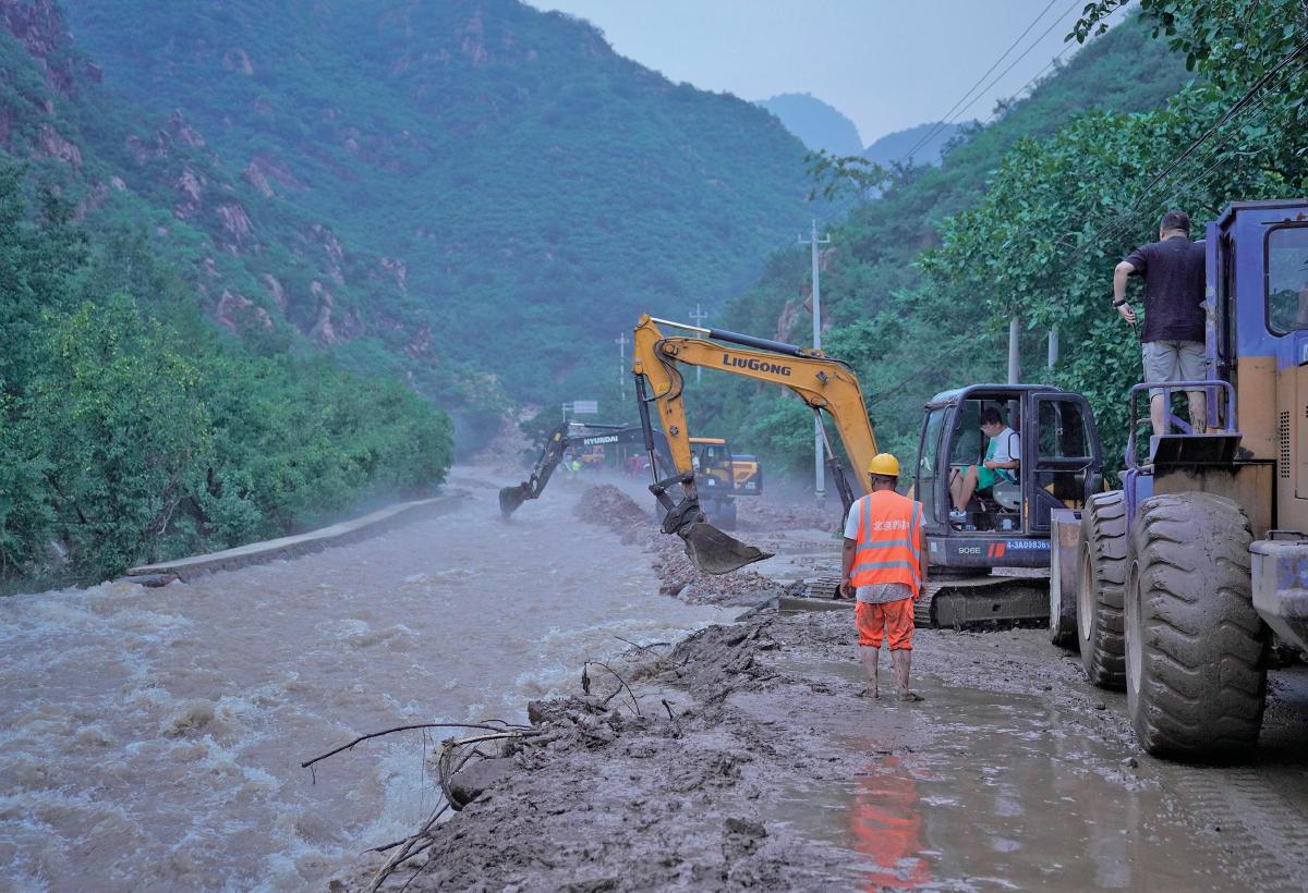 7月28日，平谷区镇罗营镇北水峪路，工作人员正在抢修道路。 新京报记者 薛珺 摄