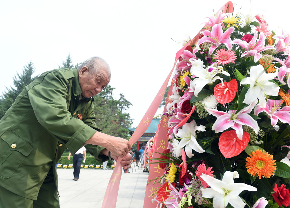 2015年8月15日，吉林省纪念东北抗联精神大会在吉林通化举行，各界群众来到通化市杨靖宇烈士陵园，缅怀牺牲的东北抗联将士。这是一位东北抗联老战士为烈士敬献花圈。 