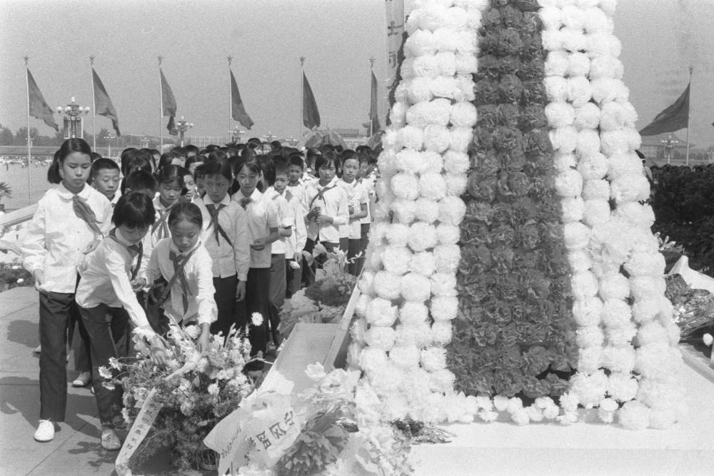 1985年，首都各界代表在天安门广场人民英雄纪念碑前举行献花圈仪式，追念在抗日战争中牺牲的将士和死难同胞。这是海淀区少先队员在敬献花圈。