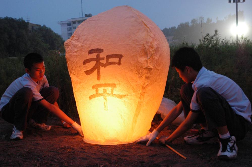 2005年8月15日，近万名各界群众聚集在哈尔滨市平房区侵华日军第七三一部队罪证陈列馆，举行祈祷和平活动。这是市民点燃孔明灯。