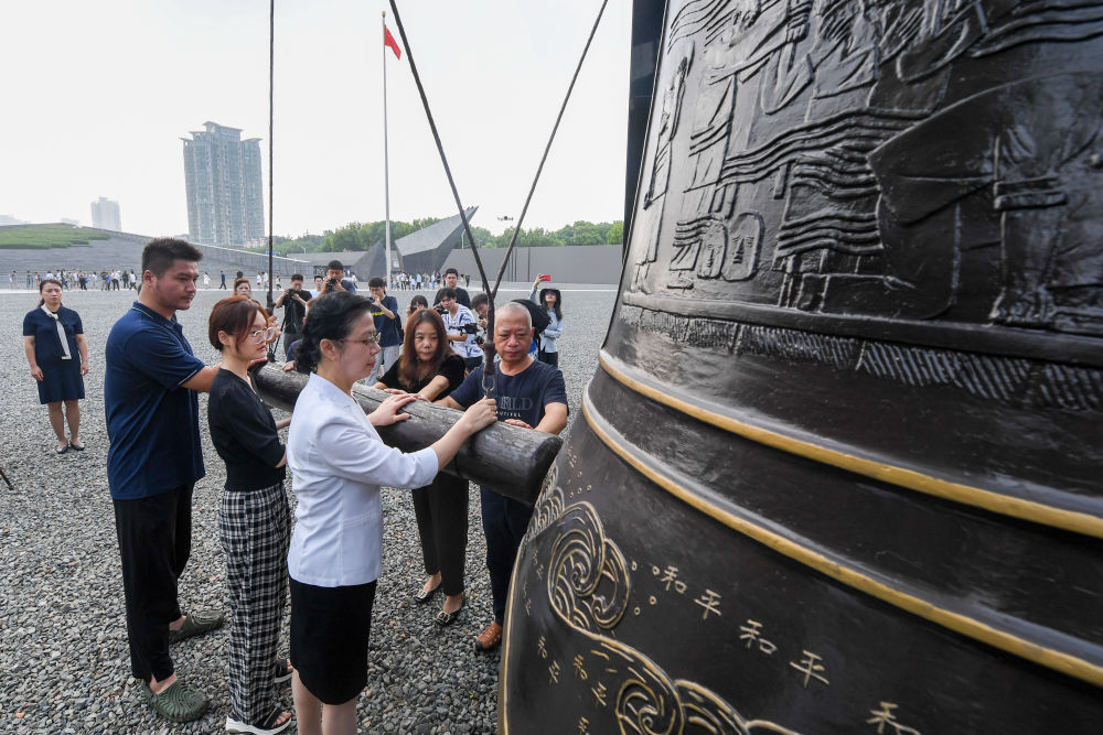 2023年8月15日，南京大屠杀幸存者后代代表在侵华日军南京大屠杀遇难同胞纪念馆公祭广场撞响和平大钟，祈福和平。