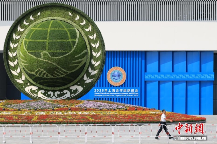 8月31日，天津，一名工作人员从2025年上海合作组织峰会主会场外的景观花坛旁经过。当日，2025年上海合作组织峰会在天津举行。<a target='_blank' href='/'>中新社</a>记者 佟郁 摄