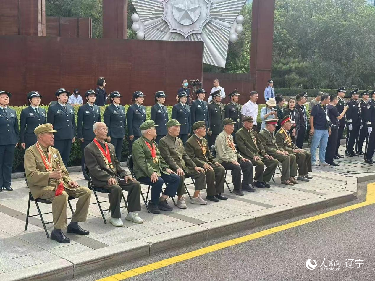 沈阳抗美援朝烈士陵园门前，志愿军老战士等候战友的归队。人民网记者 周颂雪摄