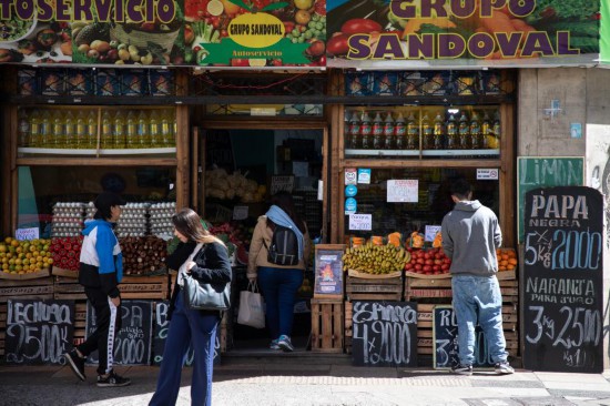 9月25日，在阿根廷首都布宜诺斯艾利斯，人们走过一家张贴着特价广告的蔬果店。新华社发（马丁&middot;萨巴拉摄）