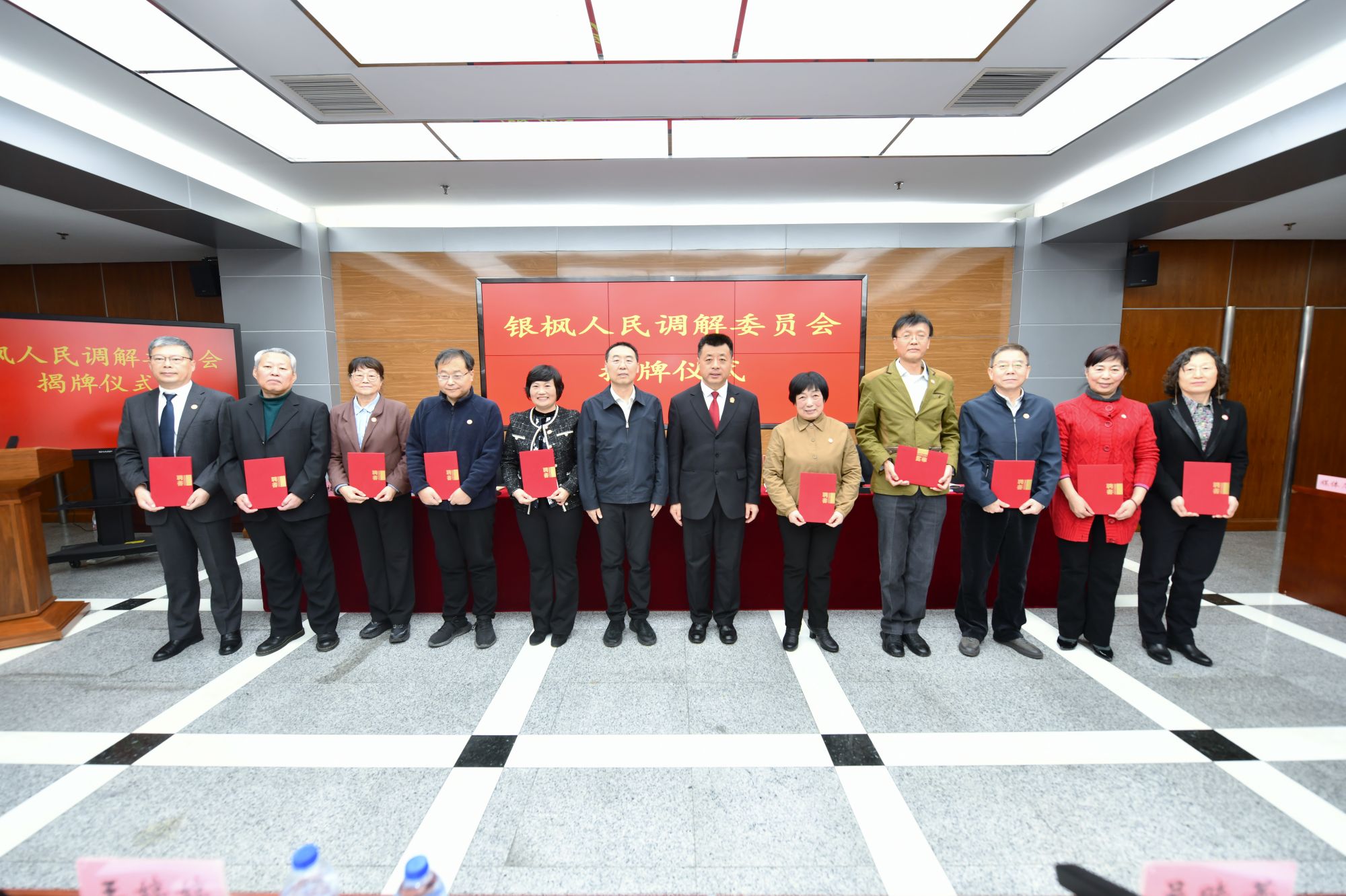 朝阳法院党组书记、院长刘海东与朝阳区司法局党组书记、局长倪东新共同为银枫人民调解委员会调解员代表颁发聘书 曹璐摄