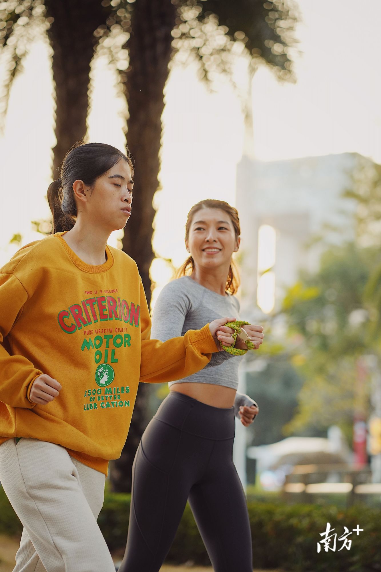 12月9日,许兴群(左)与陪跑员周皖湘(右)一起跑步。 12月9日,许兴群(左)与陪跑员周皖湘(右)一起跑步。