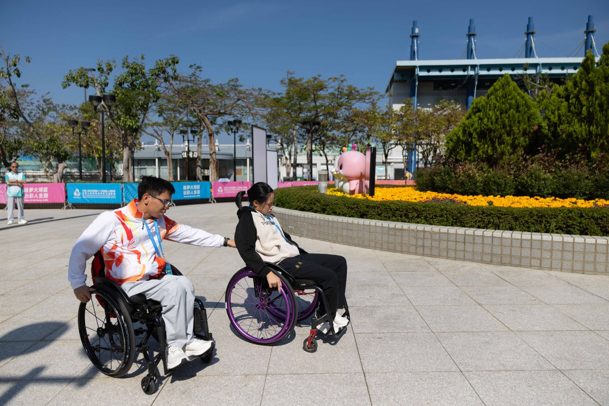 香港马鞍山体育馆外,梁绍颖帮顾文茜推轮椅。 香港马鞍山体育馆外,梁绍颖帮顾文茜推轮椅。