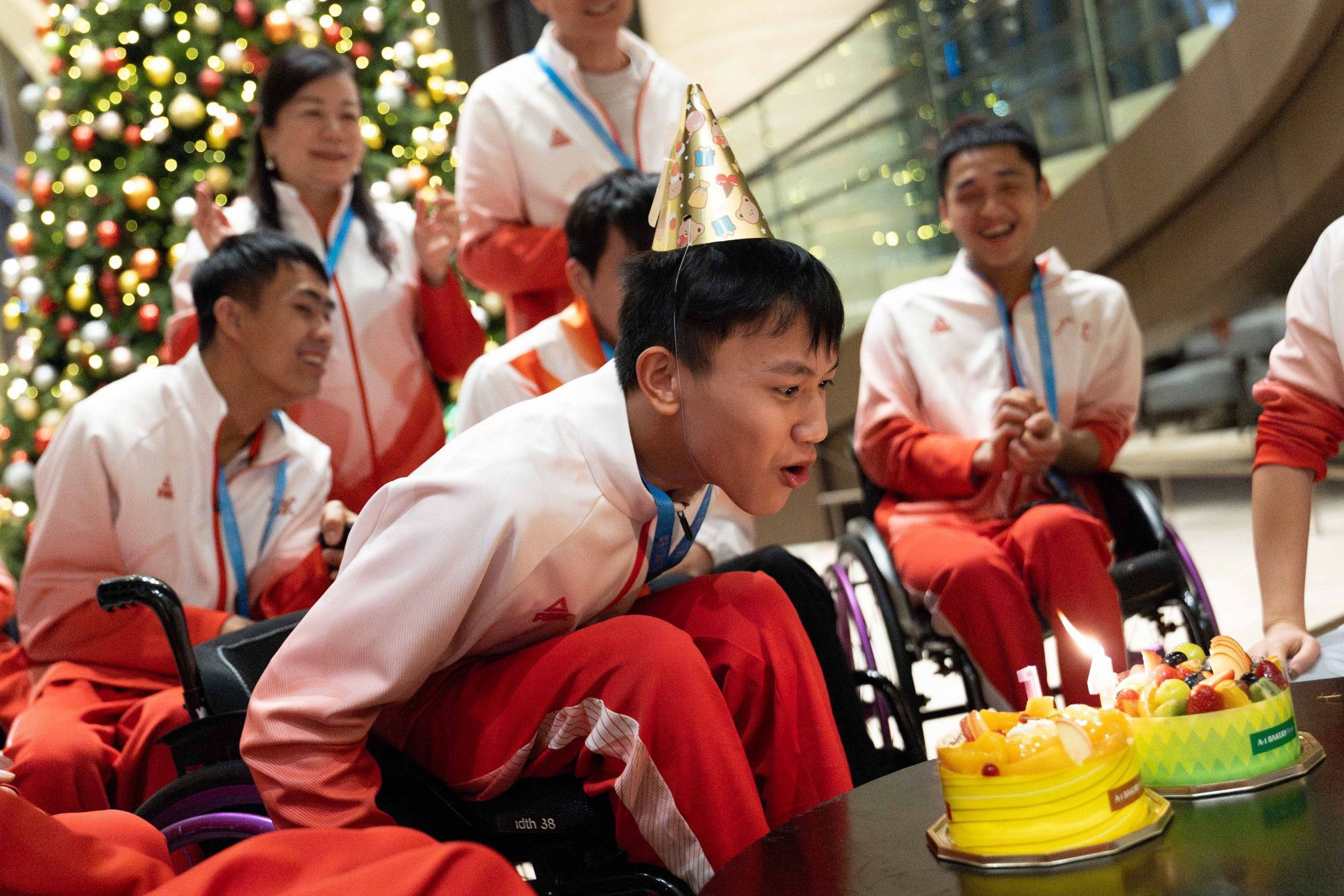 12月12日晚，在香港赛区男子花剑团体铜牌赛后，剑客最后下剑台的轮椅上吴安迪（中）与队友们显得有些失落。