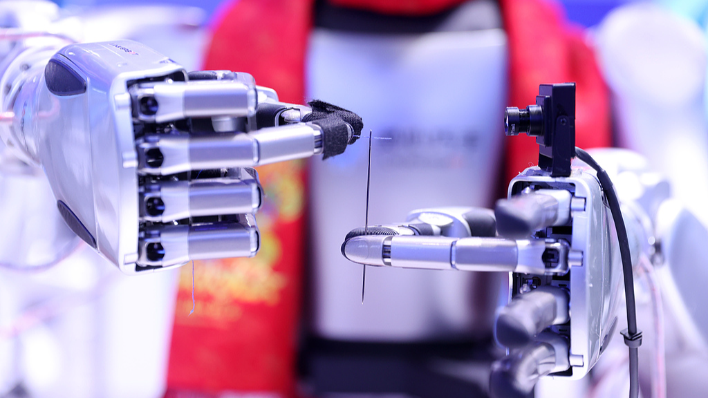 A humanoid robot showcases precision control by threading a needle at the 2026 Zhongguancun Forum Annual Conference in Beijing, March 25, 2026. /VCG