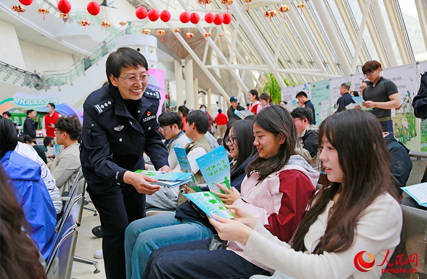民警发放禁毒宣传册。人民网记者 崔新耀摄