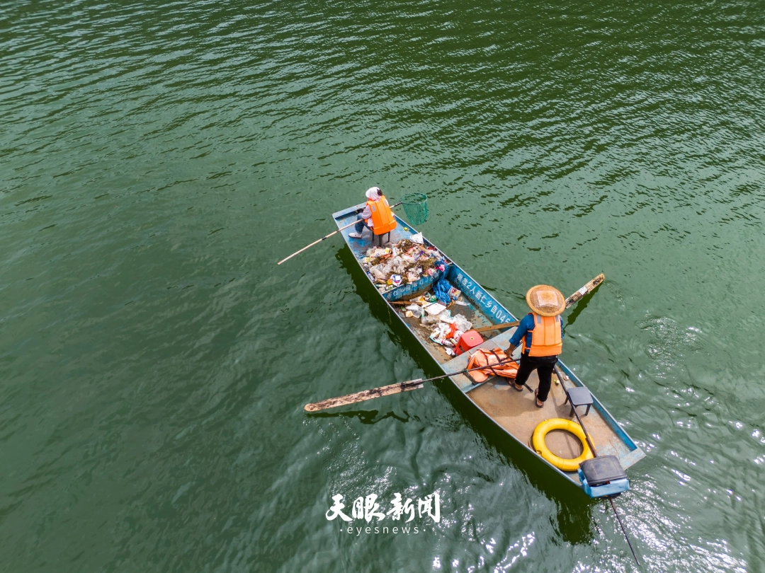17856562446867.jpg 2025年8月20日,在黔西市化屋村,杨清鑫夫妇正在乌江上打捞漂浮物,守护一江清水。罗大富 摄.jpg