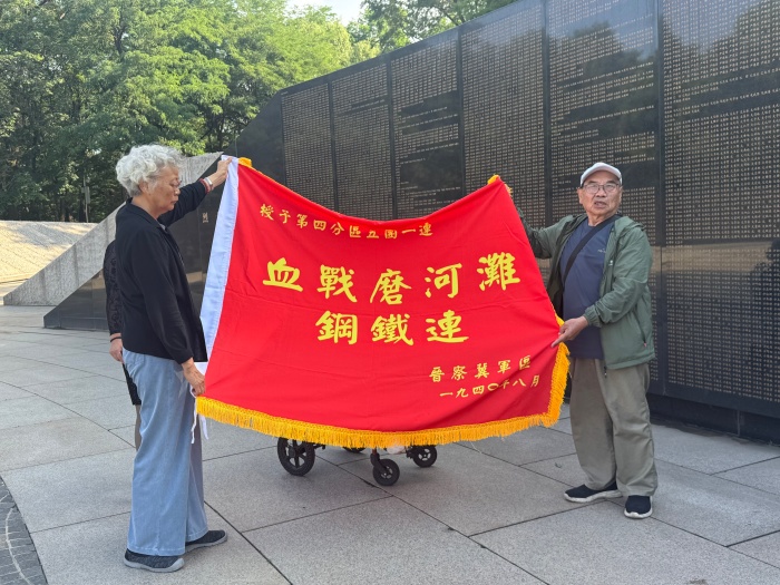 邓其平还带来&ldquo;血战磨河滩钢铁连&rdquo;战旗。人民网记者汤龙 摄